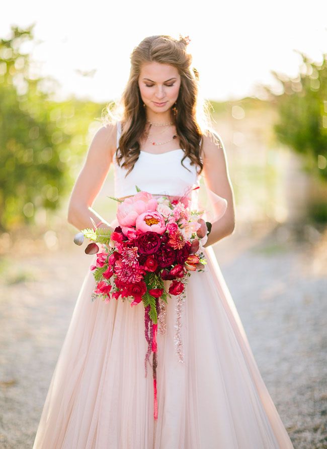 a bold light pink to red and burgundy plus greenery wedding bouquet with shiny ribbons is a fantastic statement