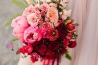 a bold ombre wedding bouquet from blush, lightpink to red and burgundy, with greenery and leaves