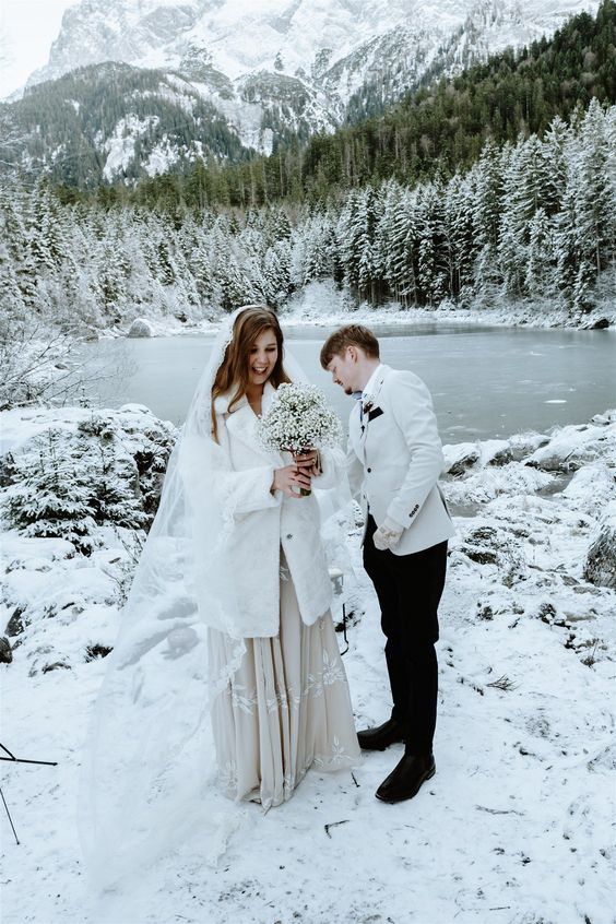 a white faux fur bridal midi coat is a cool cover up for a winter bride, looks cool and fresh