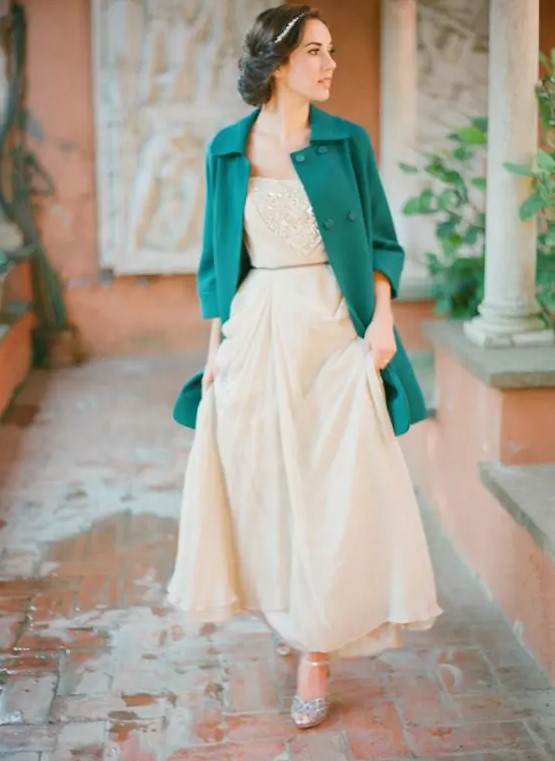 an emerald coat creates a bold accent and highlights the vintage look of the bride