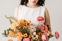 an ombre wedding bouquet from yellow, mustard, light pink and pink blooms and greenery for a modern bride