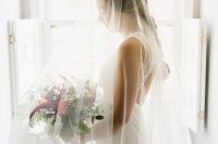 02 The bride was wearing a lace sheath wedding dress with no sleeves and a keyhole back plsu a veil