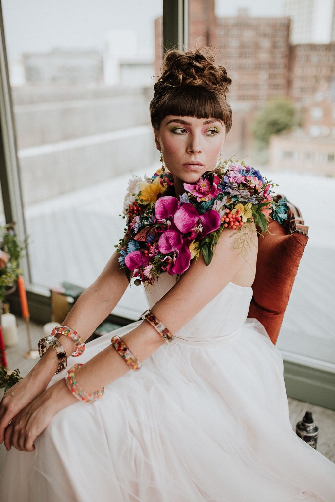 The bride was wearing a strapless wedding dress with a draped bodice and a floral cape