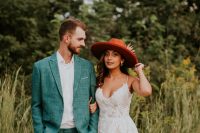 04 The groom was wearing a teal suit with a white shirt, and the bride was rocking a lace spaghetti strap dress and a red hat