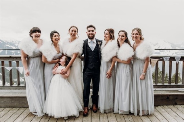 The groom was wearing a dark grey three-piece wedding suit and the bridesmaids were rocking light grey maxi dresses and faux fur coverups