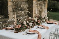 05 The wedding tablescape was done with peachy napkins, greenery, moss, blush and mauve blooms and candles