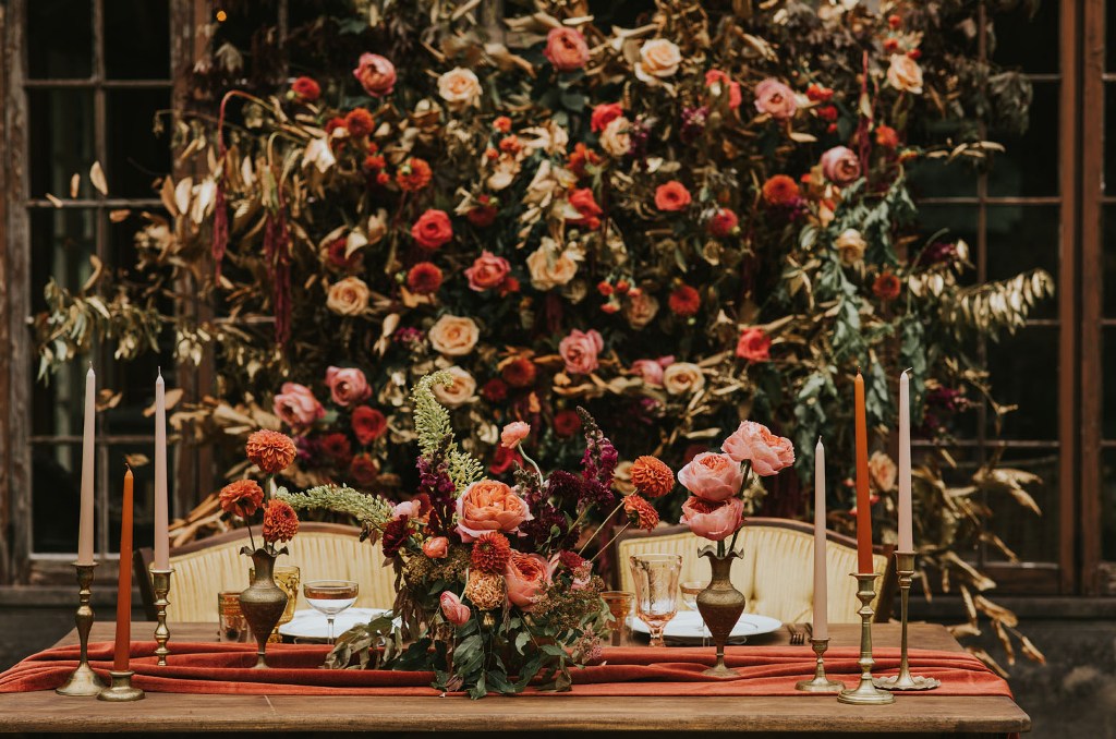 The wedding tablescape was done with the same bold flal colored blooms and greenery, colorful candles and bold linens