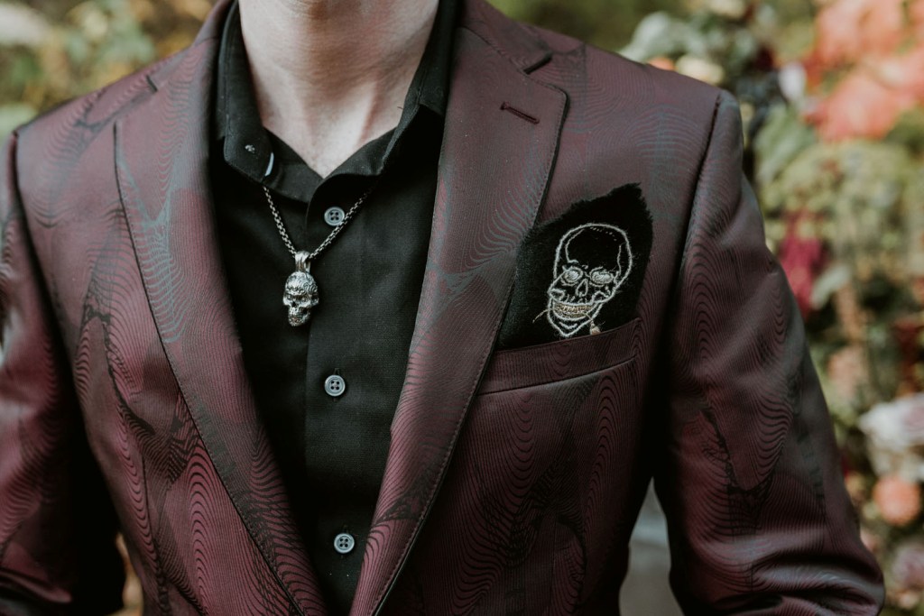 The groom was wearing a black shirt, a printed burgundy blazer and some skulls here and there