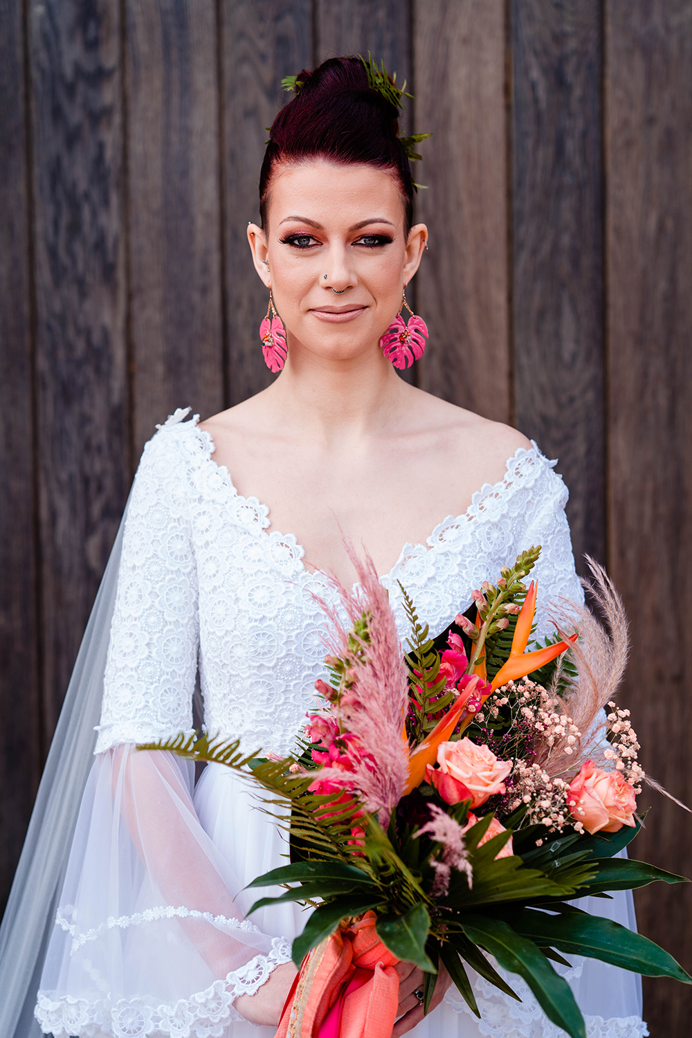 The wedding bouquet was done with pink, blush and orange blooms, leaves and pink pampas grass