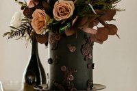 09 The wedding cake was done black and accented with dark sugar blooms, moody blooms and greenery on top