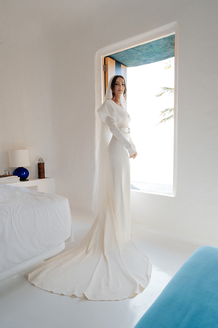 The bride was wearing a gorgeous modern wedding dress with a V-neckline, long sleeves and a train