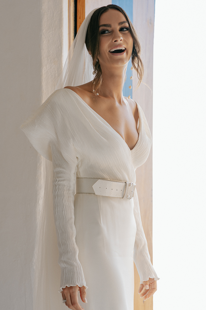 Her look was finished with a leather belt, baroque pearls earrings and a veil