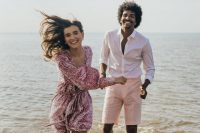 04 The couple had fun in the sea, the bride was wearing a pink sequin jumpsuit, and the groom rocked pink shorts and a white shirt