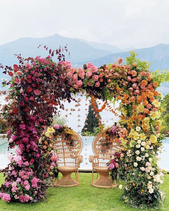a bright and lush floral wedding arch from light pink to fuchsia and light pink, then to rust and blush looks jaw-dropping