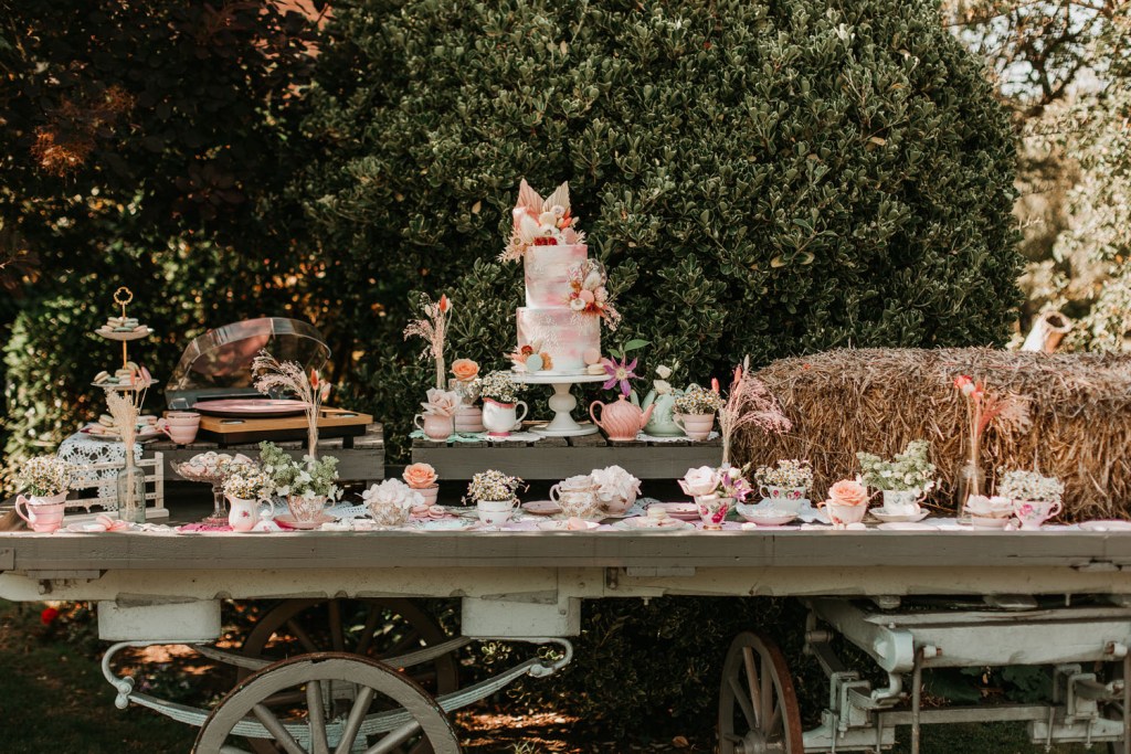 The wedding cake table was done with greenery, pastel blooms and vintage teaware