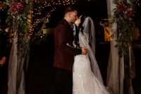 07 The wedding arch was done with white tulle, reenery, burgundy blooms and an animal skull