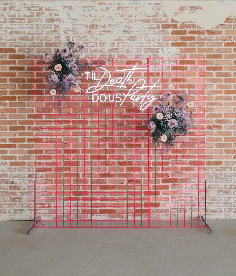 The wedding backdrop was done super bold pink, with lavender blooms and a neon sign
