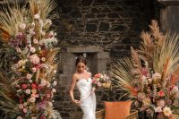 08 The wedding altar was jaw-dropping, with bold and pastle blooms, dried fronds and leaves