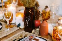 08 The wedding tablescape was done with woven placemats, dried blooms and foliage, elegant cutlery, amber glasses and terracotta vases