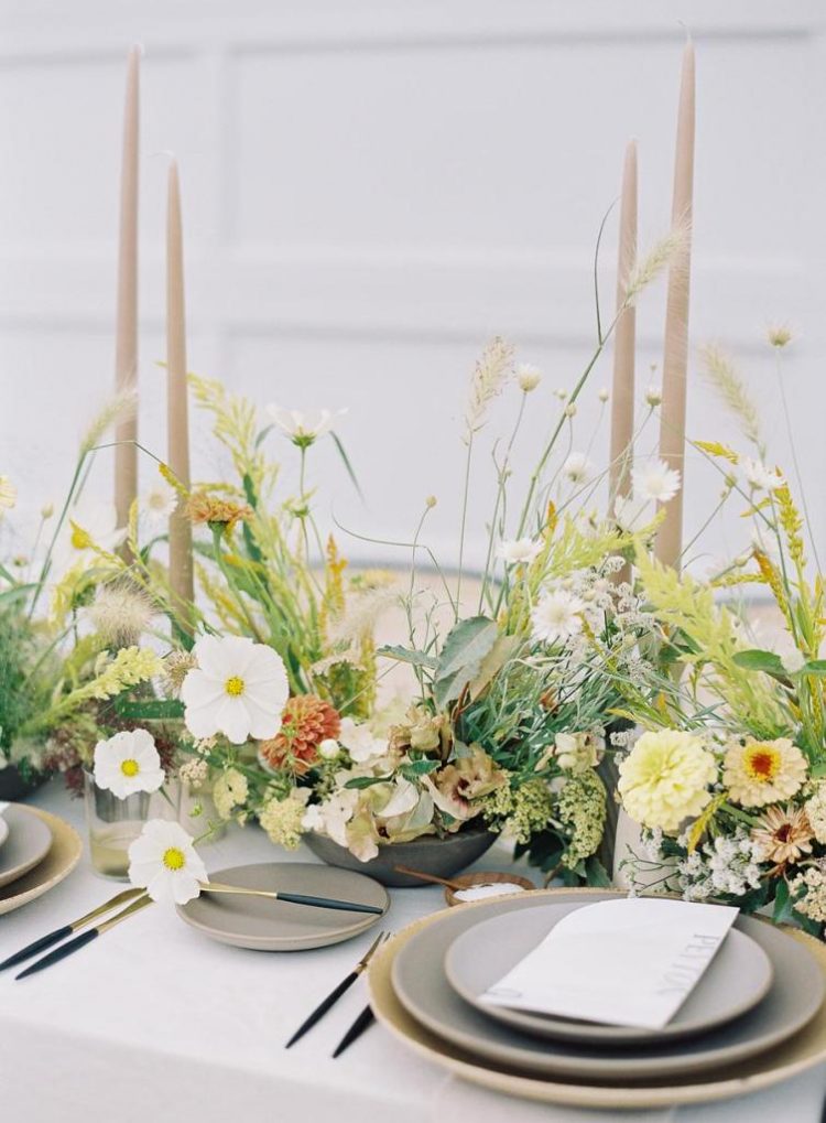 The wedding tablescape was done with bright and neutral blooms, pastel candles and grey porcelain