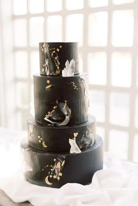 a black celestial wedding cake with gold details, moons, stars and large crystals is a great idea for a celestial wedding