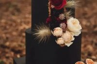 a black wedding cake with neutral, deep red and dark blooms, dried wheat and dried flowers is a lovely idea for a fall boho wedding
