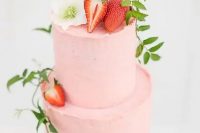 a blush wedding cake topped with a white bloom, strawberries and some greenery is a beautiful idea for a summer wedding