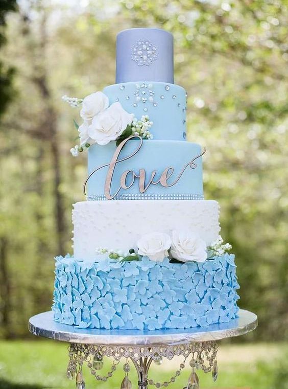 a bold powder blue wedding cake with sugar flower, pearl, sleek, embellished tiers and white blooms and berries
