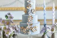a fabulous textural blue wedding cake with gold and white blooming branch detailing is amazing