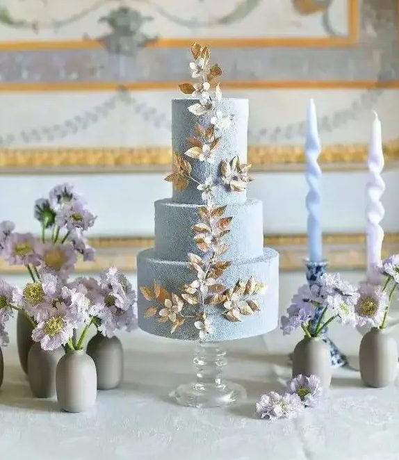 a fabulous textural blue wedding cake with gold and white blooming branch detailing is amazing
