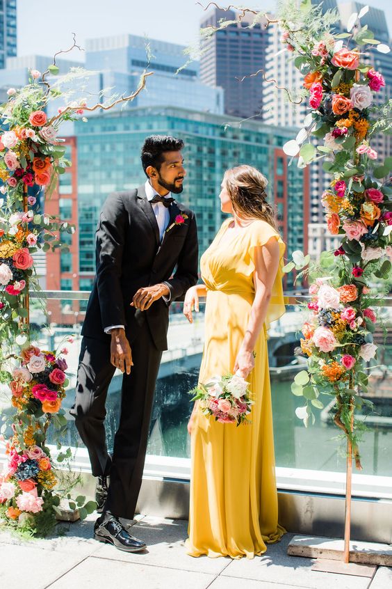 a flowy yellow wedding dress with a draped ruffle bodice for a flower-filled and bright wedding