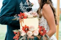 a gorgeous wedding cake with a neutral and a teal tier, watercolor macarons, bright coral blooms and greenery and a calligraphy cake topper