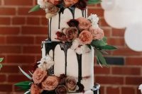 a jaw-dropping three-tier wedding cake with chocolate drip, mauve and peachy blooms, greenery is a chic idea for any wedding