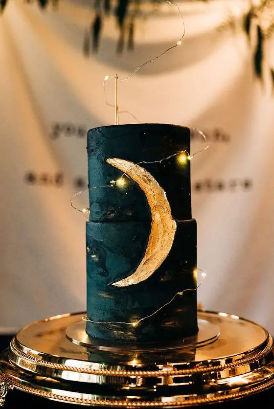 a matte black wedding cake with a gold foil moon covered with LED lights is a lovely idea for a celestial wedding