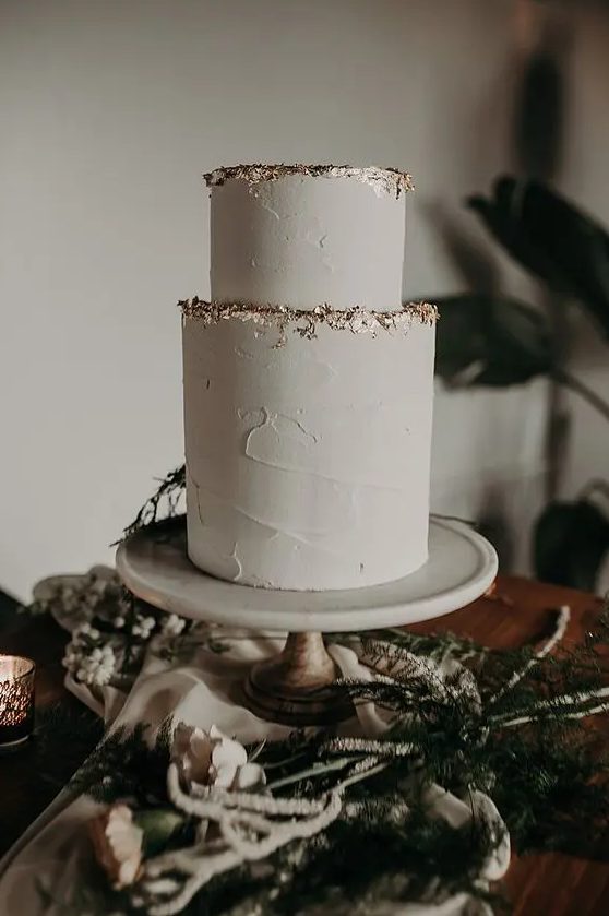 a minimalist yet glam textural neutral wedding cake decorated with a gold foil edge is a stylish idea for a minimal wedding