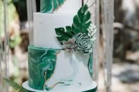 a modern tropical wedding cake with white marble and green marble tiers and sugar leaves and succulents is a very chic and cool idea