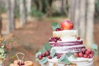 a naked fall wedding cake with apples, grapes and cranberries plus leaves for a fall wedding with a rustic touch