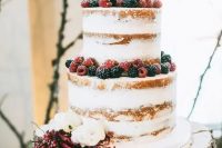 a naked wedding cake topped with fresh berries and white blooms is a stylish idea for many weddings