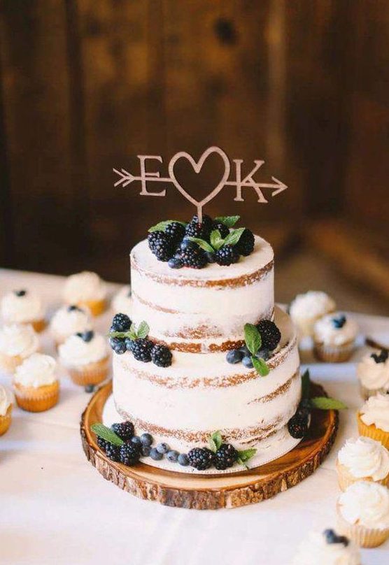 a naked wedding cake with fresh berries and mint and a cute topper is perfect for a rustic wedding