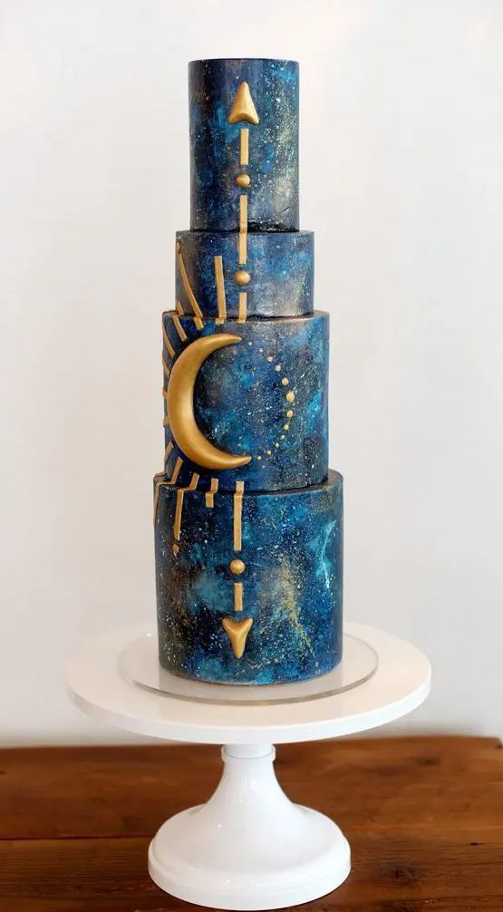 A navy galaxy themed wedding cake with gold arrows and rays, with a half moon is perfect for a celestial wedding