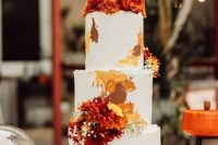 a pretty and bright wedding cake in white, with earthy tone brushstrokes and bold fresh blooms and baby’s breath for a 70s wedding