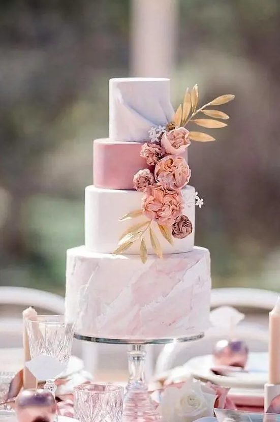 a romantic wedding cake with a white, pink and pink marble tier, dried blooms and gold foliage is a very romantic option