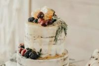 a semi-naked wedding cake with caramel drip, fresh berries and fruit and greenery is a gorgeous boho wedding dessert for a vineyard wedding