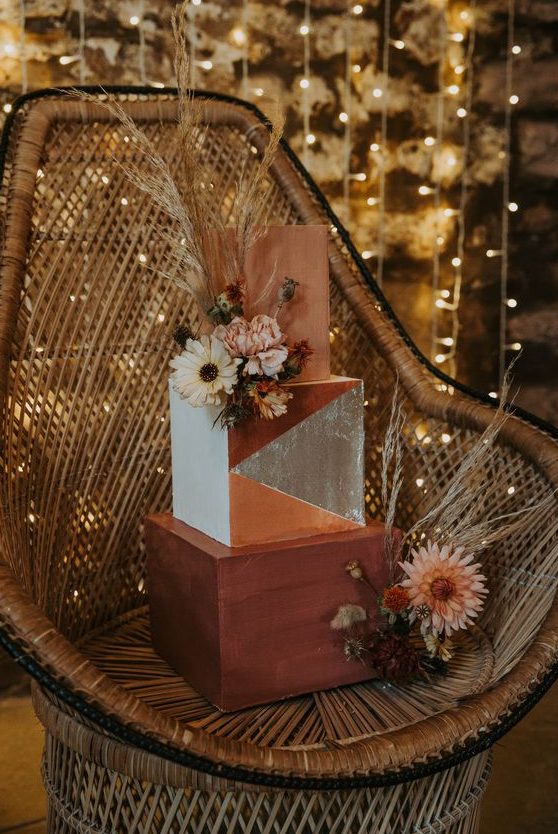 a statement square wedding cake with a terraccotta, rust and color block tier, dried blooms and pampas grass is amazing