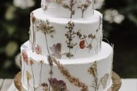 a subtle white buttercream wedding cake with pressed dried flowers and herbs is a lovely idea for a boho wedding