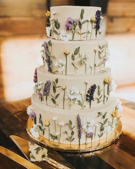 A tan wedding cake with pressed flowers and leaves looks very relaxed and boho like is a lovely idea for spring