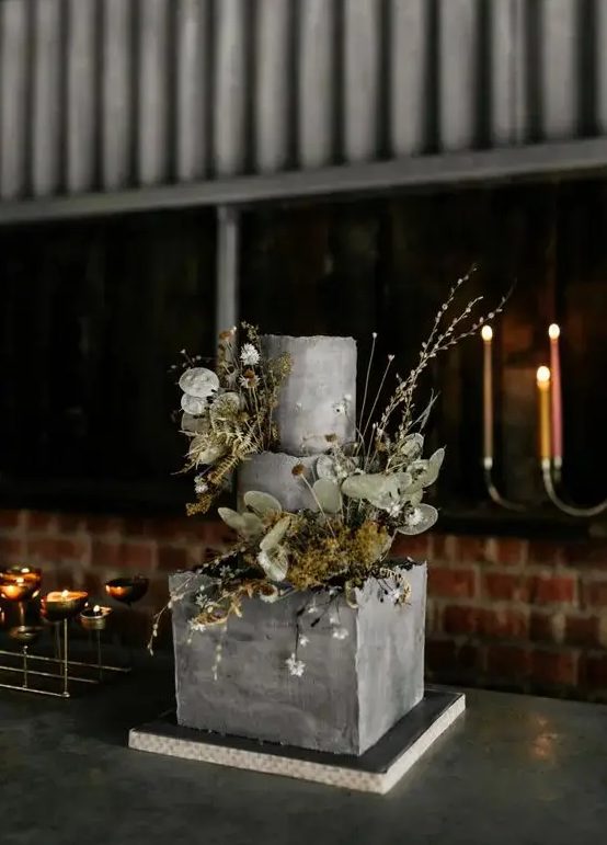 a textural grey square and round wedding cake with dried blooms, greenery and some fresh flowers is a real masterpiece