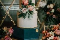 a white and teal wedding cake with neutral and pink blooms and greenery and some gold touches is pure elegance