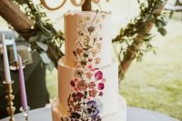 a white buttercream wedding cake with an ombre pressed flower pattern from purple to white is a lovely idea for a boho wedding