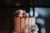 a white wedding cake with caramel drip, white blooms and meringues is a cool idea for a winter wedding